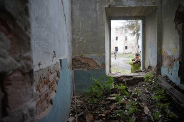 Terk edilmiş evde fotoğraf çeken bir adam.