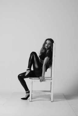 Çekici esmer güzellik sandalyede oturuyor.