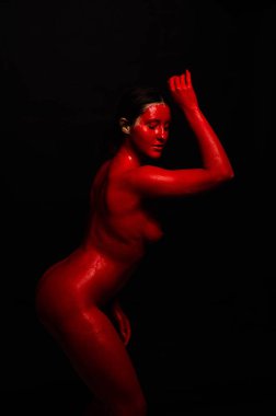 genç bir kızın yaratıcı portresi. Yüz kırmızı glitter boya ile boyanmıştır. Üçgen yüze çizilir. Siyah arka plan daki profilmodeli