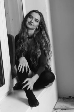 Büyük göğüslü seksi genç kadın. Siyah duvarda poz veren kız