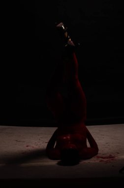 genç bir kızın yaratıcı portresi. Yüz kırmızı glitter boya ile boyanmıştır. Üçgen yüze çizilir. Siyah arka plan daki profilmodeli