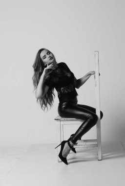 Çekici esmer güzellik sandalyede oturuyor.