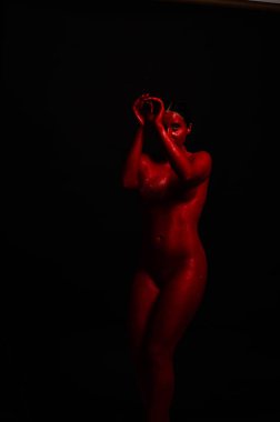 genç bir kızın yaratıcı portresi. Yüz kırmızı glitter boya ile boyanmıştır. Üçgen yüze çizilir. Siyah arka plan daki profilmodeli