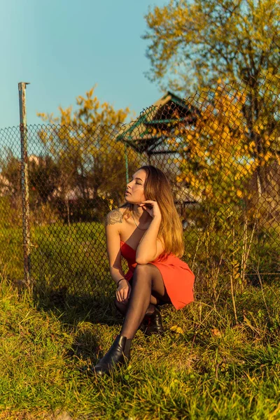 Eine Frau posiert in einem herbstlichen Park vor einer Kamera. Herbst-Fotoshooting. Herbst im Park. — Stockfoto