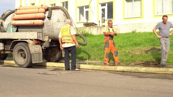Trabajador de alcantarillado en tubería de limpieza de la calle, buzo de reparación de alcantarillado Lutsk Ucrania 08 / 01 / 2018 — Foto de Stock