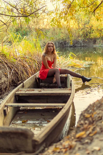 En kvinna poserar framför en kamera i en park på hösten. höst foto shoot. Hösten i parken. — Stockfoto