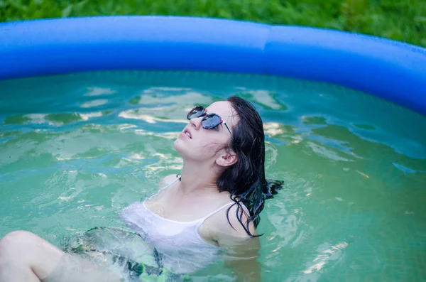 Chica en lencería y una camisa blanca se encuentra en una piscina con leche — Foto de Stock