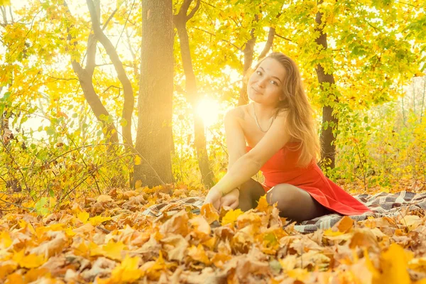 A woman is posing in front of a camera in an autumn park. autumn photo shoot. Autumn in the park. — Stock Photo, Image