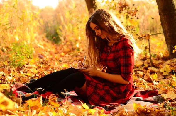 Outdoor fashion photo of young beautiful lady surrounded autumn leaves — Stock Photo, Image