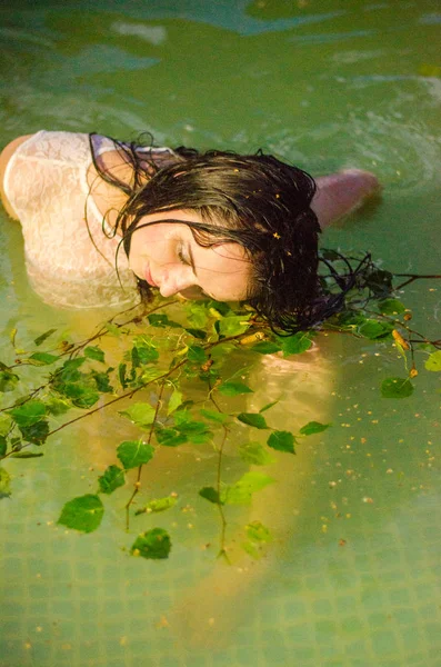 Meisje in lingerie en een wit overhemd ligt in een pool met melk — Stockfoto