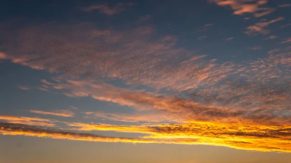 Cielo luce blu e arancione del sole attraverso le nuvole nel cielo — Foto Stock