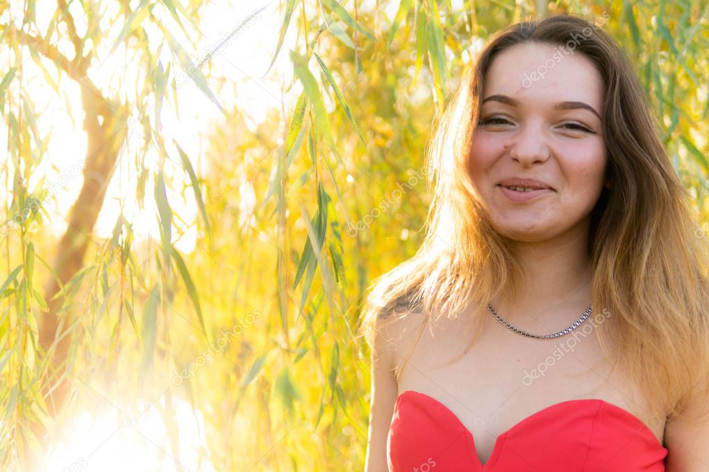 A woman is posing in front of a camera in an autumn park. autumn photo shoot. Autumn in the park.