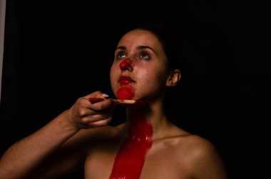 genç bir kızın yaratıcı portresi. Yüz kırmızı glitter boya ile boyanmıştır. Üçgen yüze çizilir. Siyah arka plan daki profilmodeli