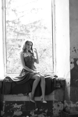 Genç, güzel, kısa saçlı, siyah elbiseli sarışın kadın.