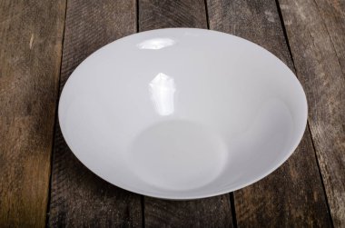 Kopya alanı ile ahşap arka plan üzerinde boş beyaz çanak ve beyaz masa örtüsü üst görünümü