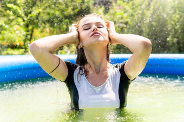 Güzel kadın model uzun akşam önlük giymiş, havuzda yatıyor ve sensually poz veriyor