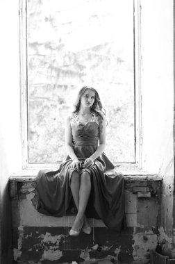 Genç, güzel, kısa saçlı, siyah elbiseli sarışın kadın.