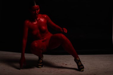 genç bir kızın yaratıcı portresi. Yüz kırmızı glitter boya ile boyanmıştır. Üçgen yüze çizilir. Siyah arka plan daki profilmodeli