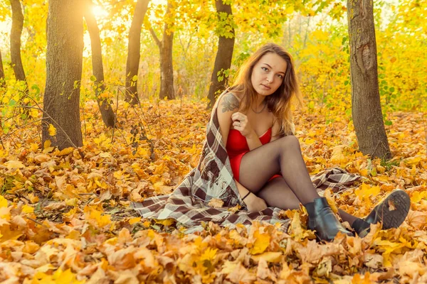 Una mujer posa delante de una cámara en un parque de otoño. sesión de fotos de otoño. Otoño en el parque . — Foto de Stock