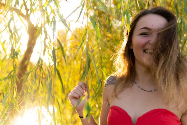 Uma mulher está posando na frente de uma câmera em um parque de outono. sessão de fotos de outono. Outono no parque . — Fotografia de Stock