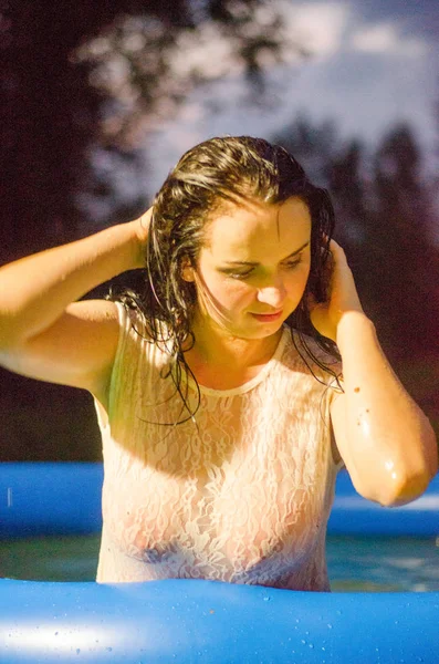 Chica en lencería y una camisa blanca se encuentra en una piscina con leche — Foto de Stock