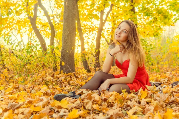 A woman is posing in front of a camera in an autumn park. autumn photo shoot. Autumn in the park. — Stock Photo, Image