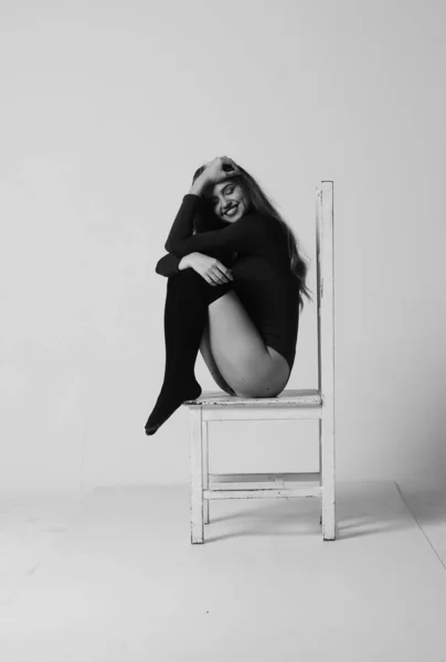 푸른 배경 스튜디오에서스 포티 한 몸을 가진 행복 한 건강 한 소녀. 예쁘게 맞는 여자 야. 흰 운동복을 입은 모델 이 의자에 앉아 있습니다. 건강 한 생활 방식. 섹시 한 여자. — 스톡 사진