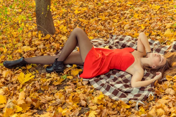 Жінка сидить перед камерою в осінньому парку. осінню фотосесію. Осінь в парку . — стокове фото