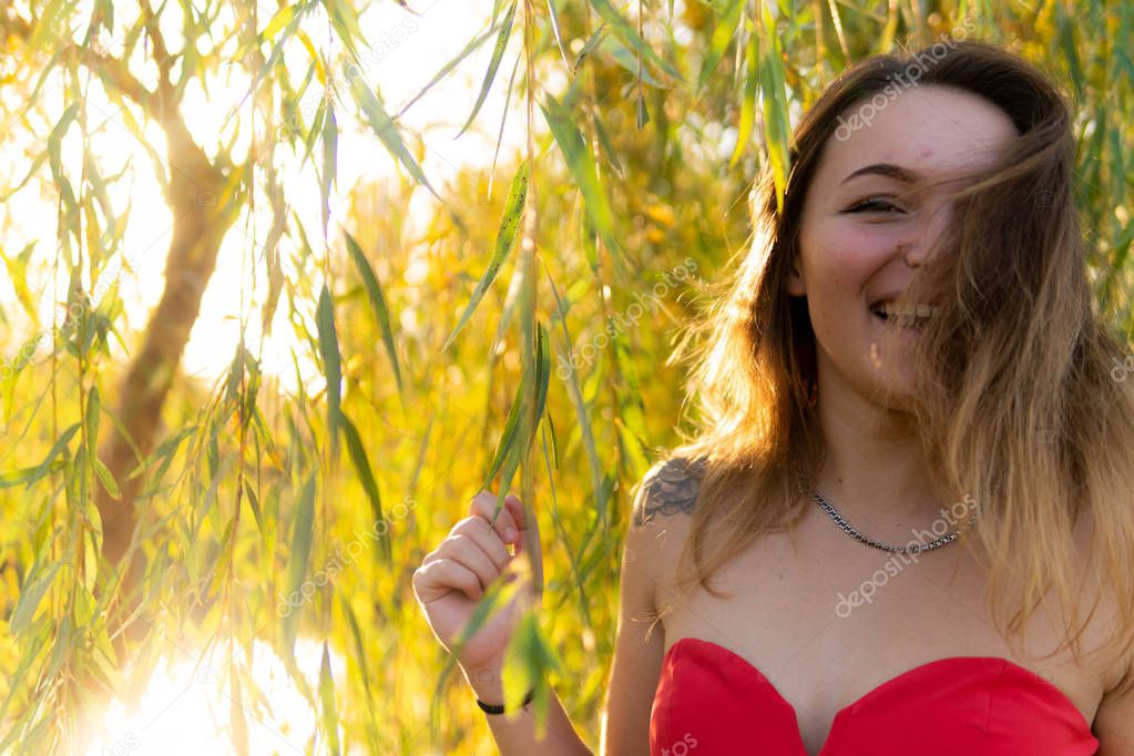 A woman is posing in front of a camera in an autumn park. autumn photo shoot. Autumn in the park.