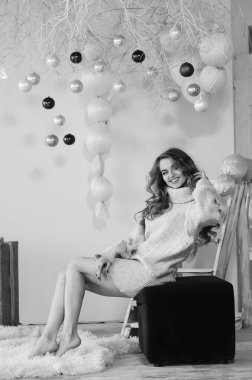 Uzun saçlı, güzel bir kadın. Elbise giymiş. Stüdyoda poz veriyor.  