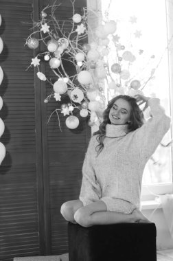 Uzun saçlı, uzun topuklu güzel bir kadın. Şenlikli bir stüdyoda poz veriyor.  