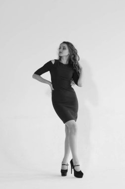 Uzun saçlı, topuklu ayakkabılı, beyaz stüdyo arka planında soyutlanmış güzel bir kadın. 