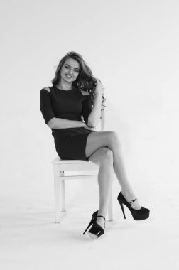 Uzun saçlı, topuklu ayakkabılı, beyaz stüdyo arka planında soyutlanmış güzel bir kadın. 