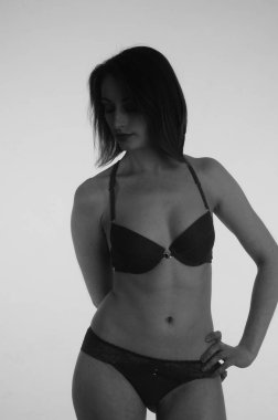 İç çamaşırlı güzel bir kadın stüdyo arkasında poz veriyor.   