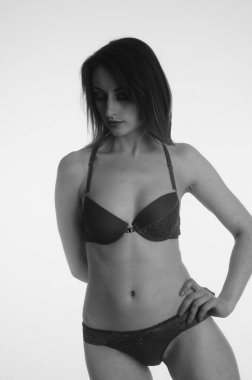 İç çamaşırlı güzel bir kadın stüdyo arkasında poz veriyor.   