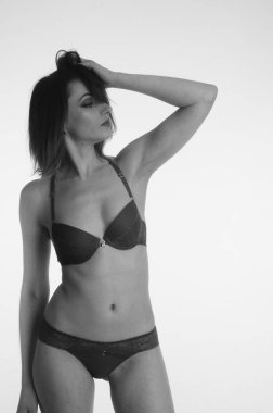 İç çamaşırlı güzel bir kadın stüdyo arkasında poz veriyor.   