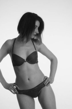 İç çamaşırlı güzel bir kadın stüdyo arkasında poz veriyor.   