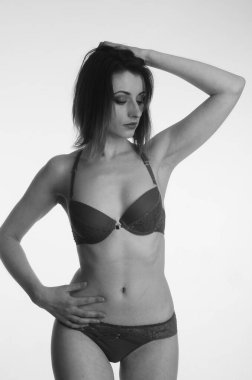 İç çamaşırlı güzel bir kadın stüdyo arkasında poz veriyor.   