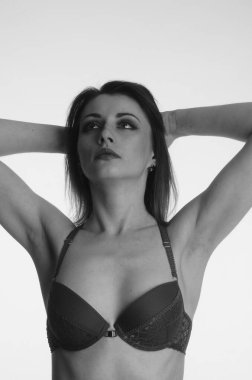 İç çamaşırlı güzel bir kadın stüdyo arkasında poz veriyor.   