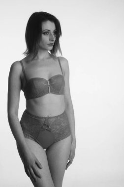 İç çamaşırlı güzel bir kadın stüdyo arkasında poz veriyor.   