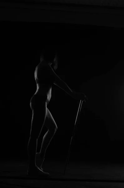 在黑暗工作室背景下摆出内衣造型的漂亮女人的轮廓 — 图库照片