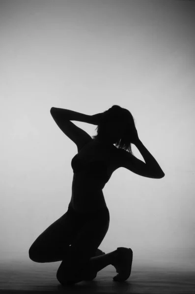 가벼운 녹음실 배경에 차림으로 포즈를 취하고 아름다운 여인의 실루엣 — 스톡 사진