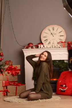 Siyah elbiseli genç bir kadın koyu bir arka planda poz veriyor, siyah saçlı ve kaslı bir spor figürü..