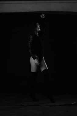 Siyah elbiseli, esmer, güzel bir kadın. Stüdyoda poz veriyor. 