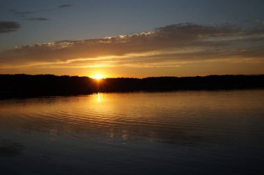 Sabahın erken saatlerinde gölün üzerinde sonsuz karanlık gökyüzü manzarası.   