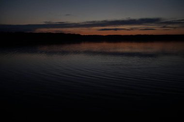 Sabahın erken saatlerinde gölün üzerinde sonsuz karanlık gökyüzü manzarası.   
