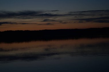 Sabahın erken saatlerinde gölün üzerinde sonsuz karanlık gökyüzü manzarası.   