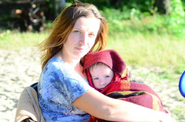 mother and her daughter sitting on the beach in the park