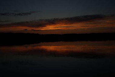 Sabahın erken saatlerinde gölün üzerinde sonsuz karanlık gökyüzü manzarası.   