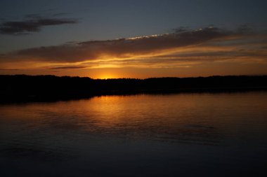 Sabahın erken saatlerinde gölün üzerinde sonsuz karanlık gökyüzü manzarası.   